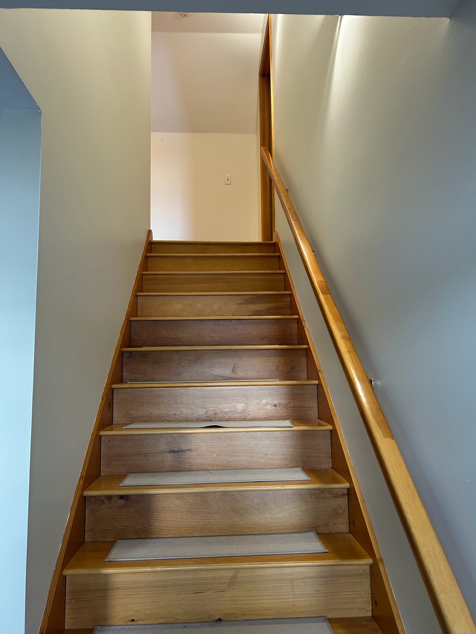 Interior staircase with light painted walls and natural wood trim