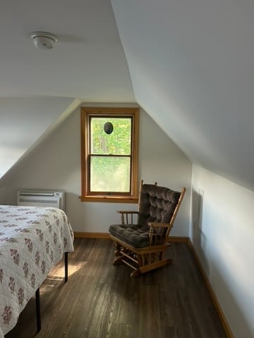 Bedroom nook with a sloped ceiling and natural wood trim